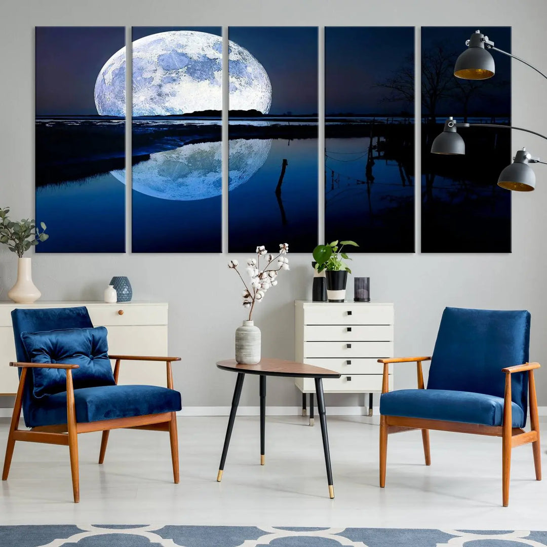 A mesmerizing Blue Moon Wall Art Canvas Print, depicting a lake landscape with a silhouetted tree, is beautifully presented on museum-quality canvas. This gallery-wrapped artwork, protected by a UV-coating to preserve its stunning details, stands out as an exquisite piece in the room.