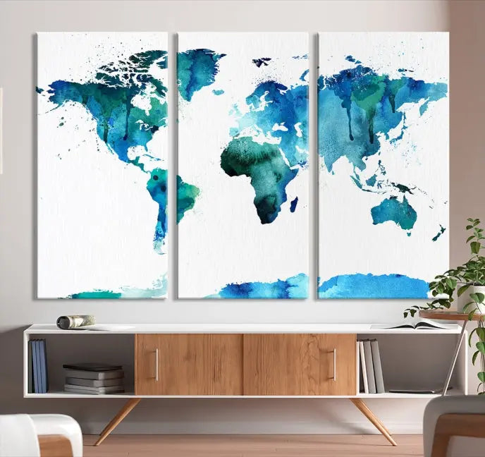 The Blue Watercolor World Map Wall Art Canvas Print features a multi-panel design in shades of blue and green, printed on museum-quality canvas with a UV-protective coating. It is ready to hang.