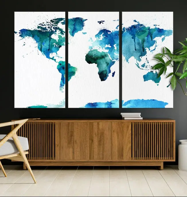 The Blue Watercolor World Map Wall Art Canvas Print features a multi-panel design in shades of blue and green, printed on museum-quality canvas with a UV-protective coating. It is ready to hang.