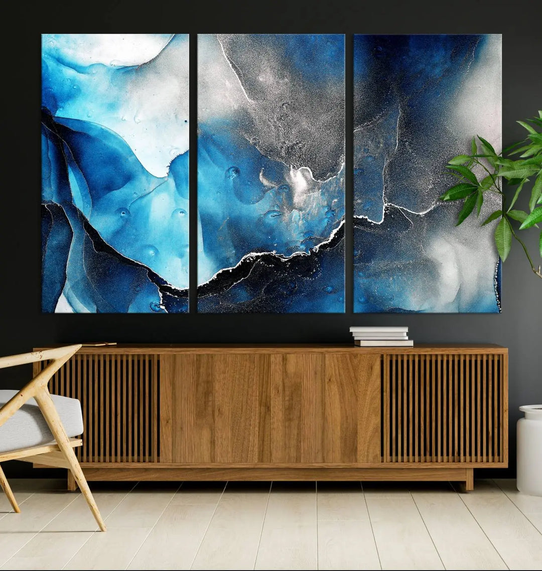 The Blue and Black Marble Fluid Effect Wall Art Abstract Canvas Prints feature three dynamic swirling patterns in blue, black, and white. Crafted on museum-quality canvases and enhanced with a UV-protective coating, these prints maintain their vibrant allure over time.