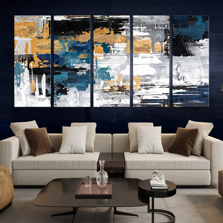 The Blue and Gold Abstract Canvas Wall Art – a triptych modern painting that's framed and ready to hang – features captivating brush strokes in blue, gold, black, and white to enhance the living room decor.