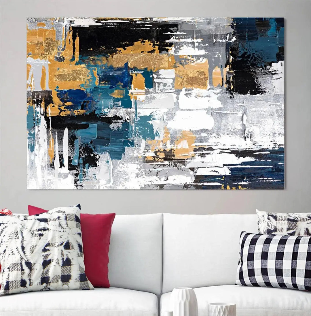 The Blue and Gold Abstract Canvas Wall Art – a triptych modern painting that's framed and ready to hang – features captivating brush strokes in blue, gold, black, and white to enhance the living room decor.