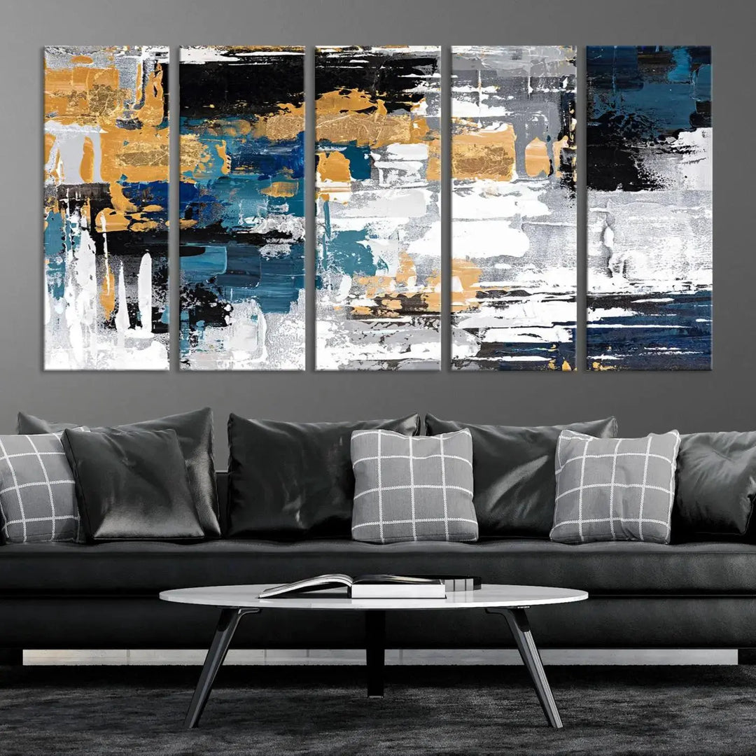 The Blue and Gold Abstract Canvas Wall Art – a triptych modern painting that's framed and ready to hang – features captivating brush strokes in blue, gold, black, and white to enhance the living room decor.