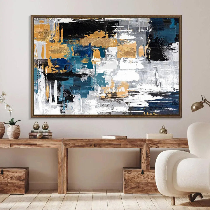 The Blue and Gold Abstract Canvas Wall Art – a triptych modern painting that's framed and ready to hang – features captivating brush strokes in blue, gold, black, and white to enhance the living room decor.