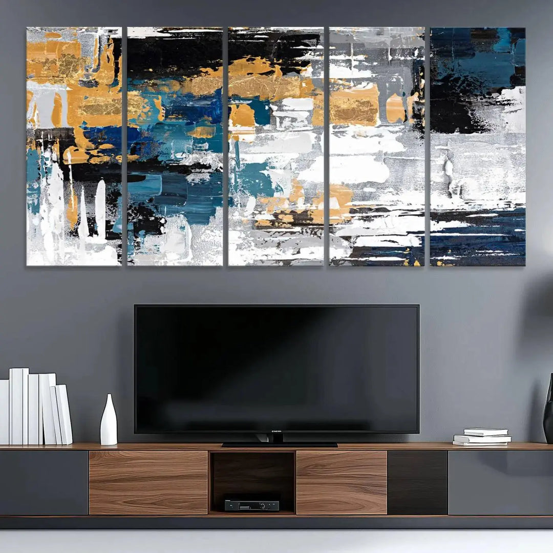 The Blue and Gold Abstract Canvas Wall Art – a triptych modern painting that's framed and ready to hang – features captivating brush strokes in blue, gold, black, and white to enhance the living room decor.