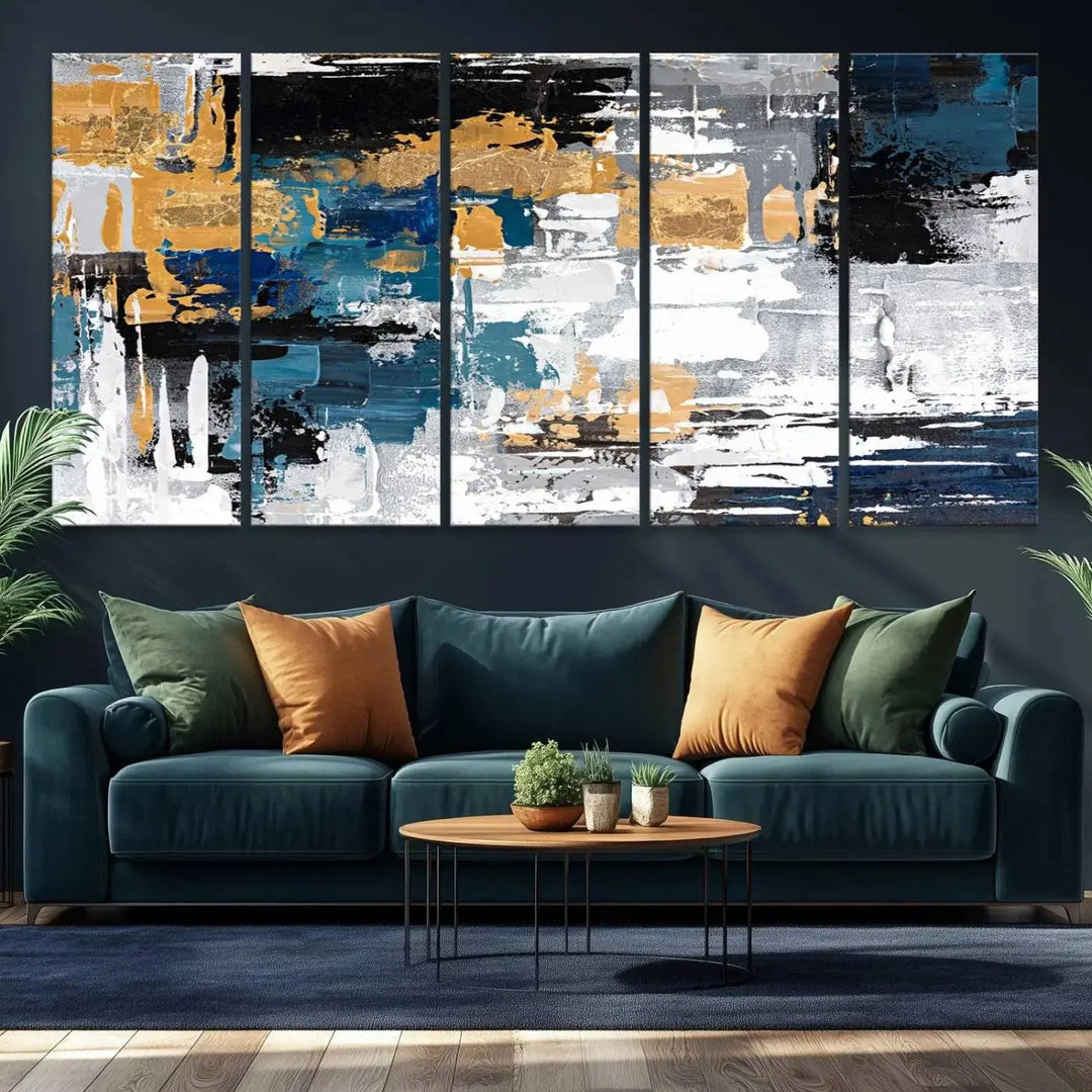 The Blue and Gold Abstract Canvas Wall Art – a triptych modern painting that's framed and ready to hang – features captivating brush strokes in blue, gold, black, and white to enhance the living room decor.