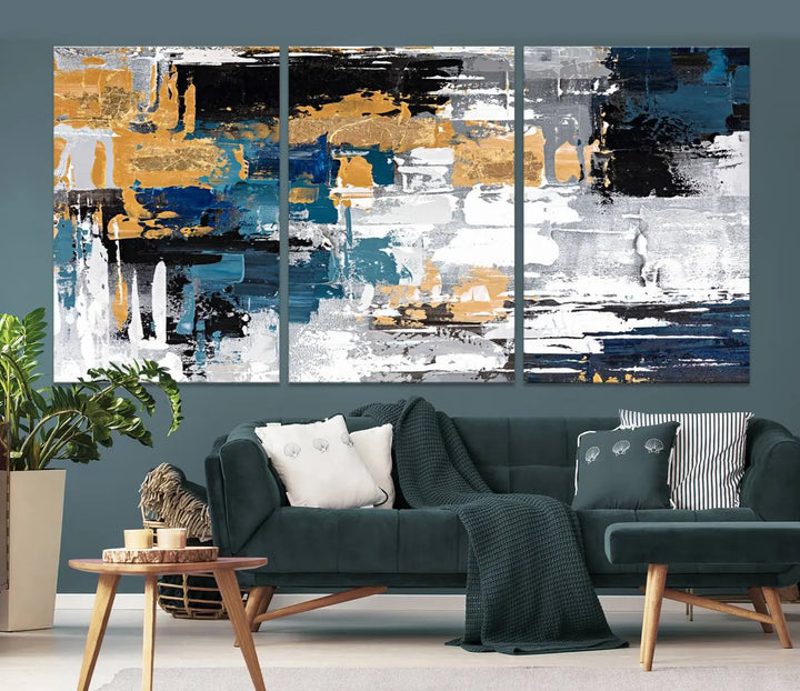 A sophisticated display of the Blue and Gold Abstract Canvas Wall Art – Triptych Modern Painting, featuring a captivating blend of blue, gold, black, and white tones, is elegantly framed and ready to hang.