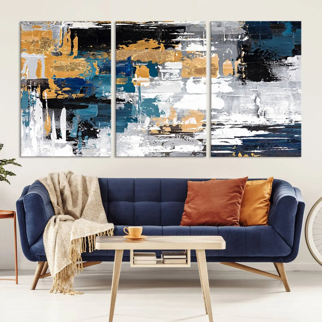 A sophisticated display of the Blue and Gold Abstract Canvas Wall Art – Triptych Modern Painting, featuring a captivating blend of blue, gold, black, and white tones, is elegantly framed and ready to hang.