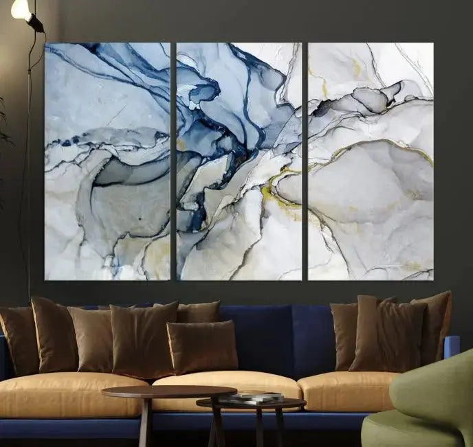 The "Blue and Gray Marble Fluid Effect Wall Art Abstract Canvas Wall Art Print" graces the dark wall, ready to hang. This triptych abstract art boasts a UV-protective coating for vibrant longevity in your space.