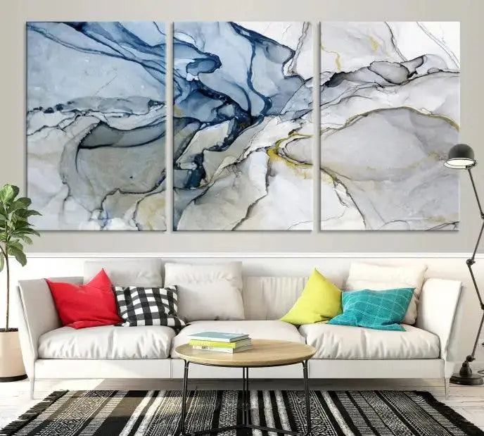 The "Blue and Gray Marble Fluid Effect Wall Art Abstract Canvas Wall Art Print" graces the dark wall, ready to hang. This triptych abstract art boasts a UV-protective coating for vibrant longevity in your space.