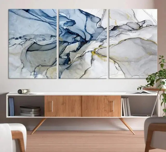 The "Blue and Gray Marble Fluid Effect Wall Art Abstract Canvas Wall Art Print" graces the dark wall, ready to hang. This triptych abstract art boasts a UV-protective coating for vibrant longevity in your space.