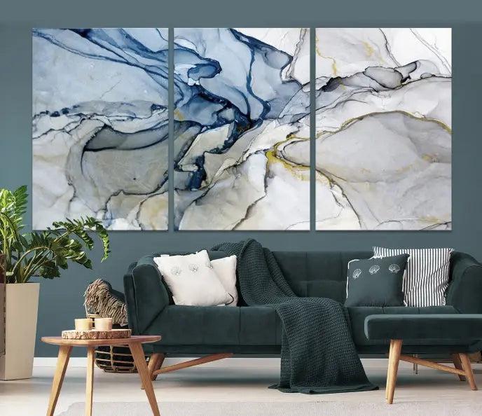 The "Blue and Gray Marble Fluid Effect Wall Art Abstract Canvas Wall Art Print" graces the dark wall, ready to hang. This triptych abstract art boasts a UV-protective coating for vibrant longevity in your space.