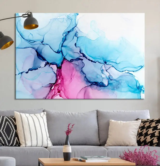 The "Blue and Pink Marble Fluid Effect Wall Art Abstract Canvas Wall Art Print" graces a dark wall. This exquisite piece is created on museum-quality polycotton canvas with a UV-protective coating.