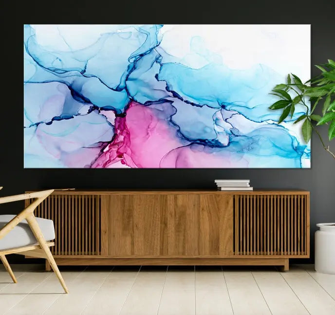 The "Blue and Pink Marble Fluid Effect Wall Art Abstract Canvas Wall Art Print" graces a dark wall. This exquisite piece is created on museum-quality polycotton canvas with a UV-protective coating.