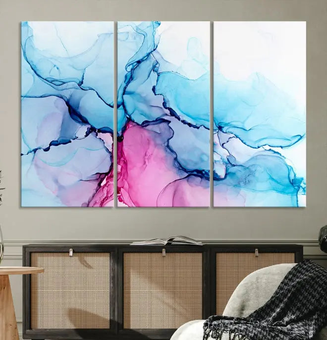 The "Blue and Pink Marble Fluid Effect Wall Art Abstract Canvas Wall Art Print" graces a dark wall. This exquisite piece is created on museum-quality polycotton canvas with a UV-protective coating.