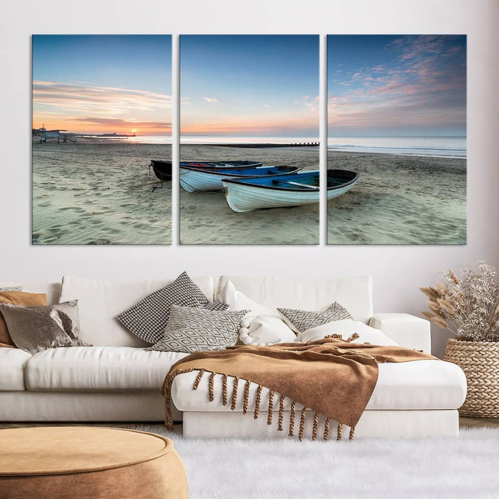 The "Boats On The Beach Wall Art Canvas Print," featuring a triptych photo of boats at sunset, is printed on museum-quality canvas with a UV-protective coating.