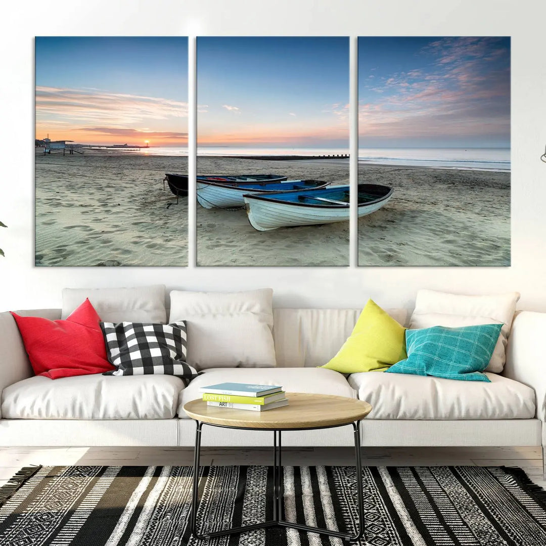 The "Boats On The Beach Wall Art Canvas Print," featuring a triptych photo of boats at sunset, is printed on museum-quality canvas with a UV-protective coating.