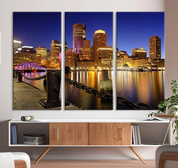 The "Boston City Night Skyline Cityscape View Wall Art Canvas Print" beautifully portrays a stunning triptych of a city skyline illuminated against the night sky, elegantly reflected in the river below. These museum-quality canvases are gallery wrapped to ensure an elegant presentation that enhances any space.