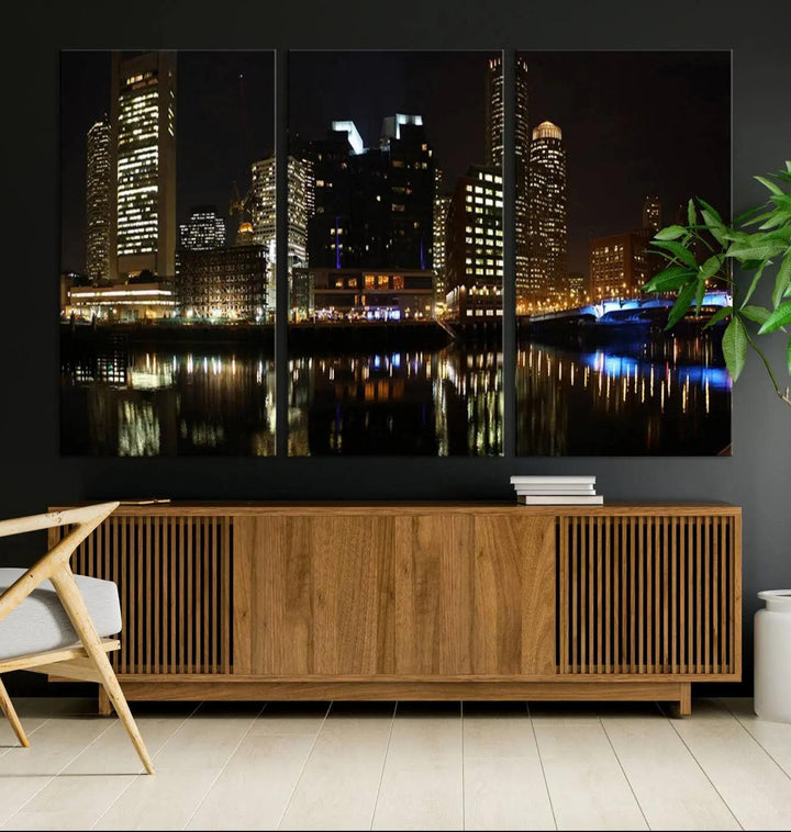 The Boston Night Skyline Cityscape View Wall Art Canvas Print depicts a triptych of the illuminated city reflected in water, enhancing a modern living room with its vibrant imagery. This gallery-wrapped masterpiece on museum-quality canvas brings an artistic flair to your space.