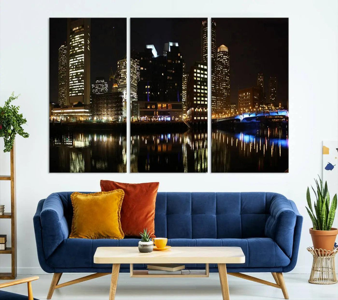 The Boston Night Skyline Cityscape View Wall Art Canvas Print depicts a triptych of the illuminated city reflected in water, enhancing a modern living room with its vibrant imagery. This gallery-wrapped masterpiece on museum-quality canvas brings an artistic flair to your space.