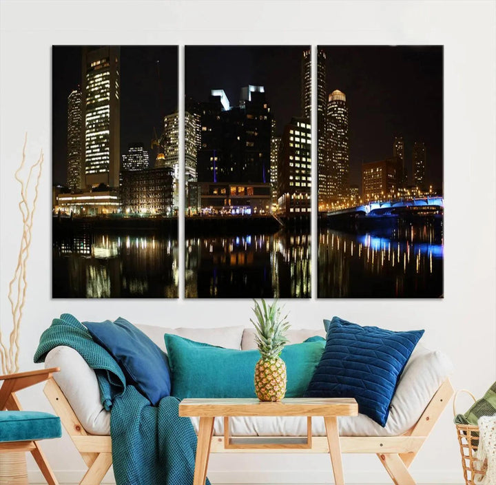 The Boston Night Skyline Cityscape View Wall Art Canvas Print depicts a triptych of the illuminated city reflected in water, enhancing a modern living room with its vibrant imagery. This gallery-wrapped masterpiece on museum-quality canvas brings an artistic flair to your space.