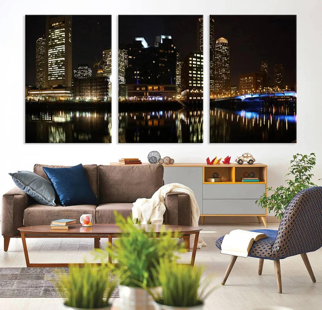 The Boston Night Skyline Cityscape View Wall Art Canvas Print depicts a triptych of the illuminated city reflected in water, enhancing a modern living room with its vibrant imagery. This gallery-wrapped masterpiece on museum-quality canvas brings an artistic flair to your space.