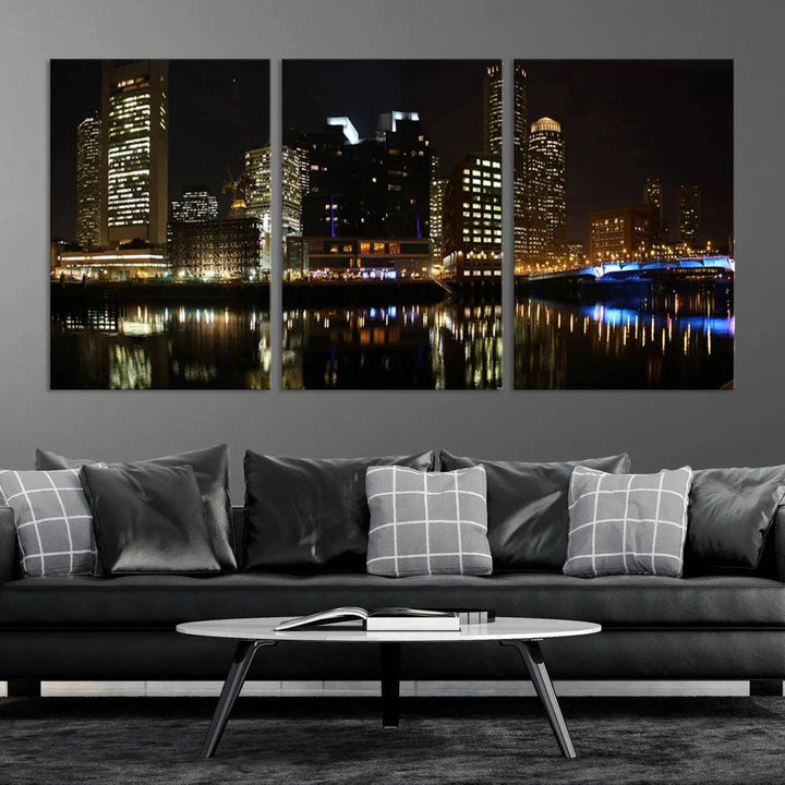 The Boston Night Skyline Cityscape View Wall Art Canvas Print depicts a triptych of the illuminated city reflected in water, enhancing a modern living room with its vibrant imagery. This gallery-wrapped masterpiece on museum-quality canvas brings an artistic flair to your space.