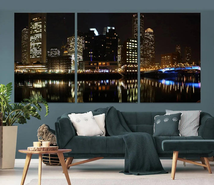 The Boston Night Skyline Cityscape View Wall Art Canvas Print depicts a triptych of the illuminated city reflected in water, enhancing a modern living room with its vibrant imagery. This gallery-wrapped masterpiece on museum-quality canvas brings an artistic flair to your space.