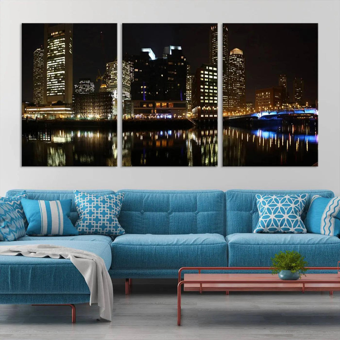 The Boston Night Skyline Cityscape View Wall Art Canvas Print depicts a triptych of the illuminated city reflected in water, enhancing a modern living room with its vibrant imagery. This gallery-wrapped masterpiece on museum-quality canvas brings an artistic flair to your space.