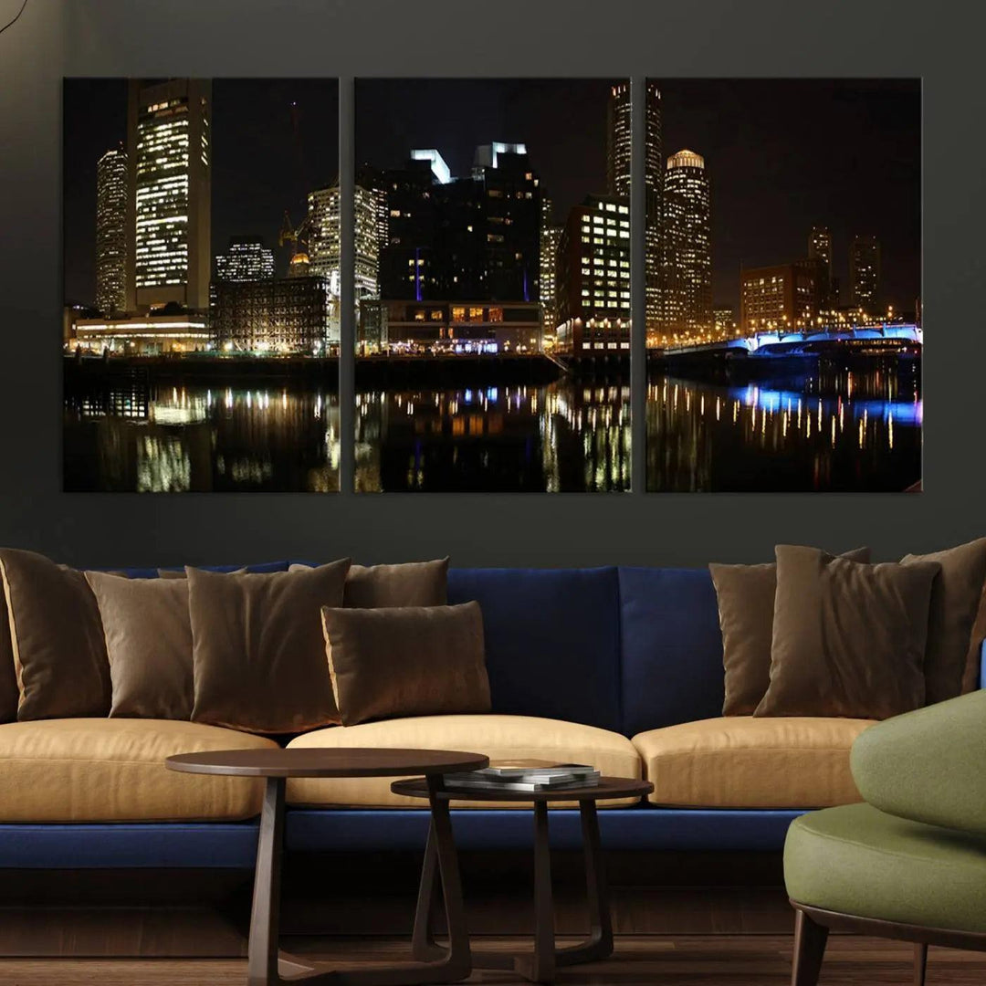 The Boston Night Skyline Cityscape View Wall Art Canvas Print depicts a triptych of the illuminated city reflected in water, enhancing a modern living room with its vibrant imagery. This gallery-wrapped masterpiece on museum-quality canvas brings an artistic flair to your space.