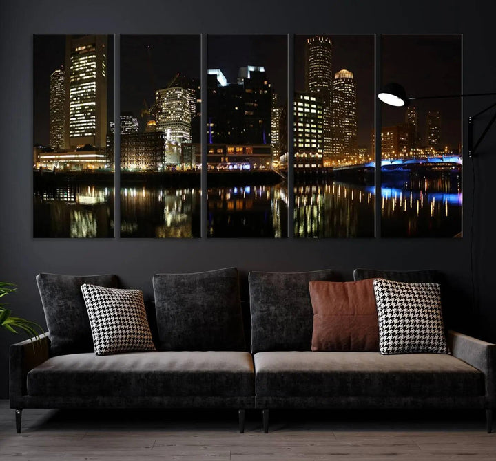 The Boston Night Skyline Cityscape View Wall Art Canvas Print depicts a triptych of the illuminated city reflected in water, enhancing a modern living room with its vibrant imagery. This gallery-wrapped masterpiece on museum-quality canvas brings an artistic flair to your space.