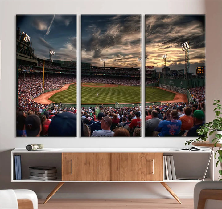 The Boston Red Sox Baseball Team Print, featuring Massachusetts's Fenway Park Stadium, brings charm and a gallery-quality finish to a cozy living room. It captures the essence of a crowded baseball stadium at sunset.