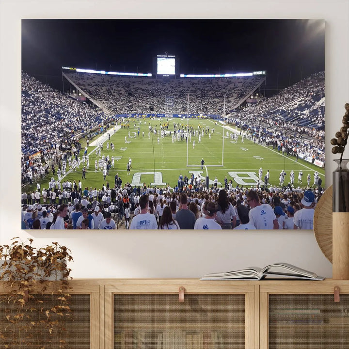 The living room is enhanced by a stunning triptych featuring the Brigham Young University Cougars Football Team Print. This premium canvas captures the vibrant atmosphere of Provo's LaVell Edwards Stadium at night, vividly portraying spectators and players on a well-lit field to bring an electrifying ambiance into your home.