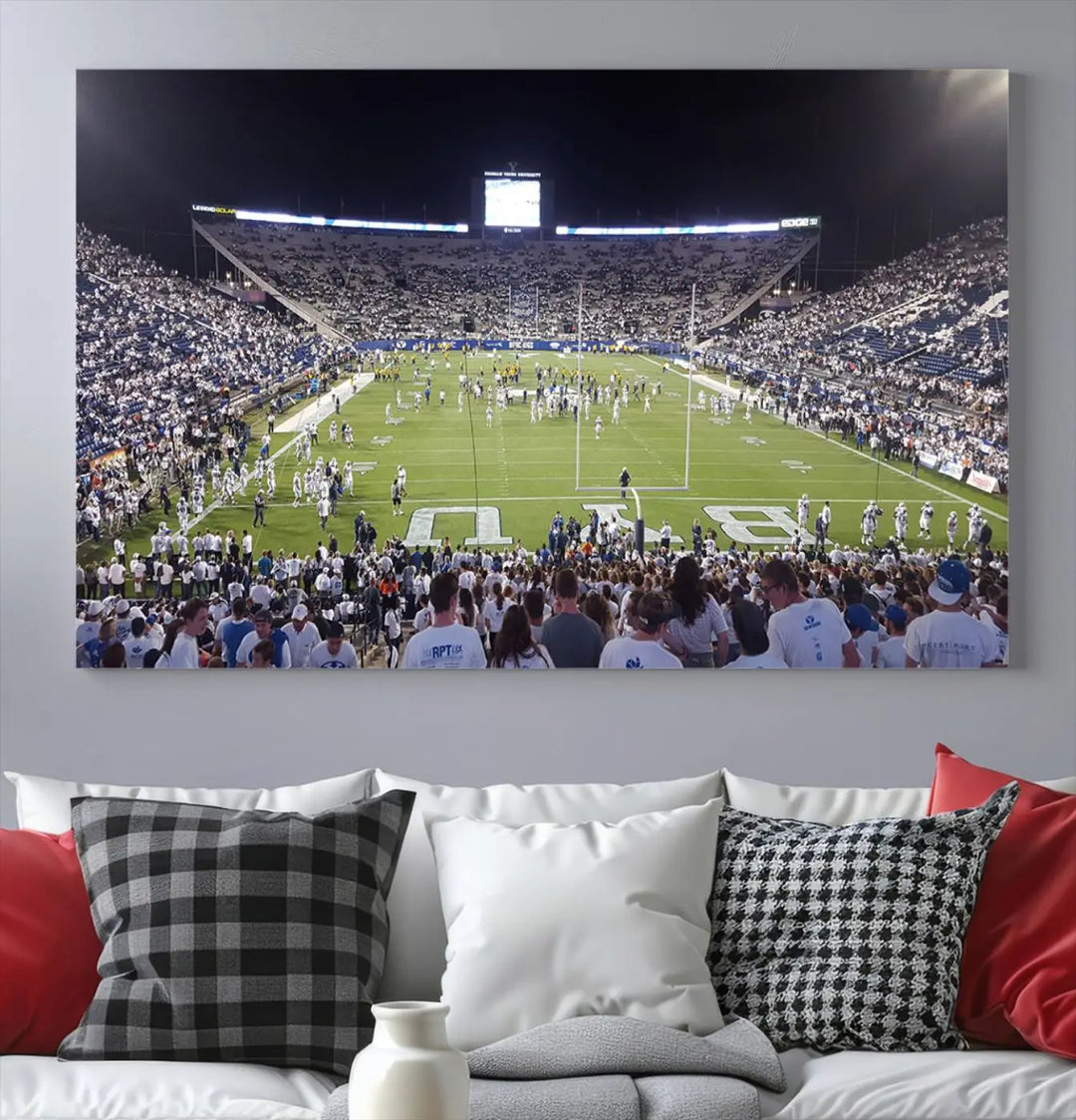 The living room is enhanced by a stunning triptych featuring the Brigham Young University Cougars Football Team Print. This premium canvas captures the vibrant atmosphere of Provo's LaVell Edwards Stadium at night, vividly portraying spectators and players on a well-lit field to bring an electrifying ambiance into your home.