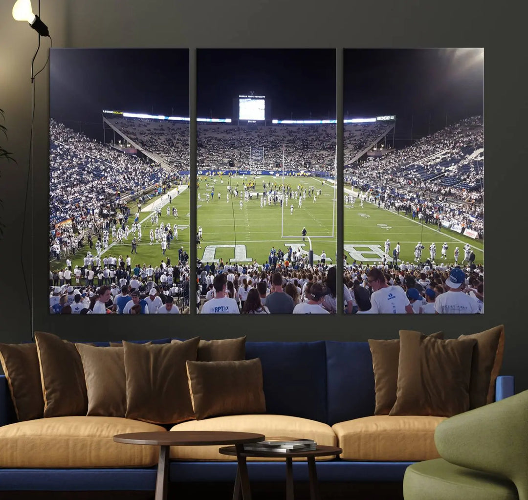 The living room is enhanced by a stunning triptych featuring the Brigham Young University Cougars Football Team Print. This premium canvas captures the vibrant atmosphere of Provo's LaVell Edwards Stadium at night, vividly portraying spectators and players on a well-lit field to bring an electrifying ambiance into your home.