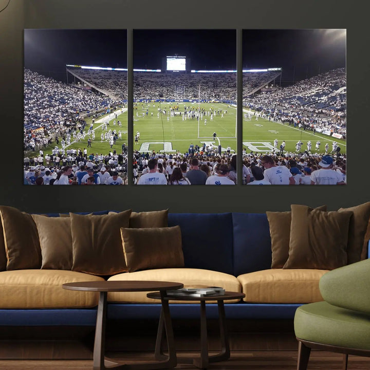 The living room is enhanced by a stunning triptych featuring the Brigham Young University Cougars Football Team Print. This premium canvas captures the vibrant atmosphere of Provo's LaVell Edwards Stadium at night, vividly portraying spectators and players on a well-lit field to bring an electrifying ambiance into your home.