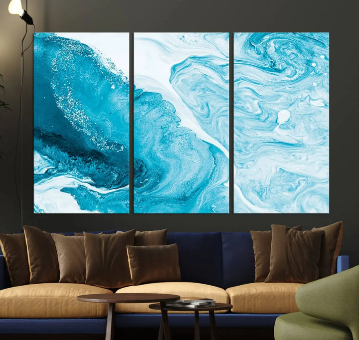 A modern living room showcasing the Bright Blue Marble Fluid Effect Wall Art Abstract Canvas, complete with a gallery-wrapped finish.