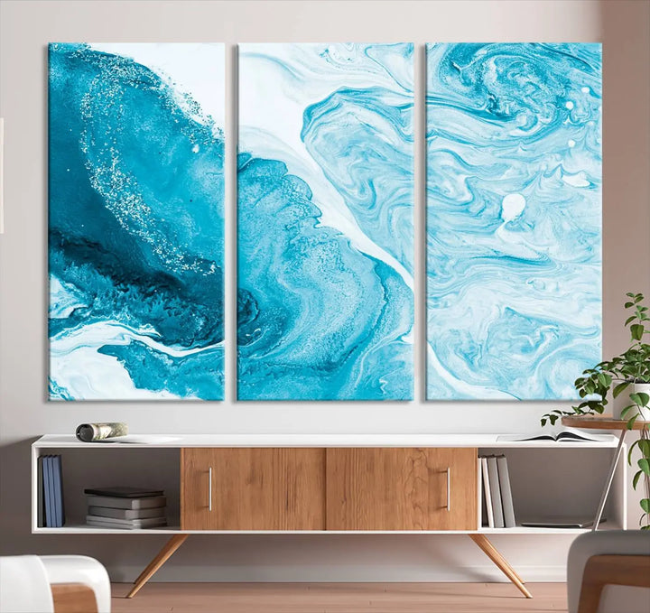 A modern living room showcasing the Bright Blue Marble Fluid Effect Wall Art Abstract Canvas, complete with a gallery-wrapped finish.