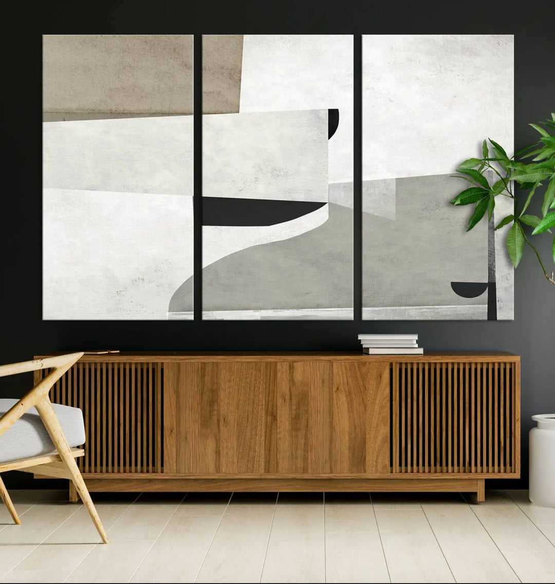 The Brown Gray Figures Abstract Wall Art Canvas Print is displayed as a triptych on a dark wall. The piece is gallery wrapped, offering a seamless finish and enhanced durability due to its UV-protective coating.