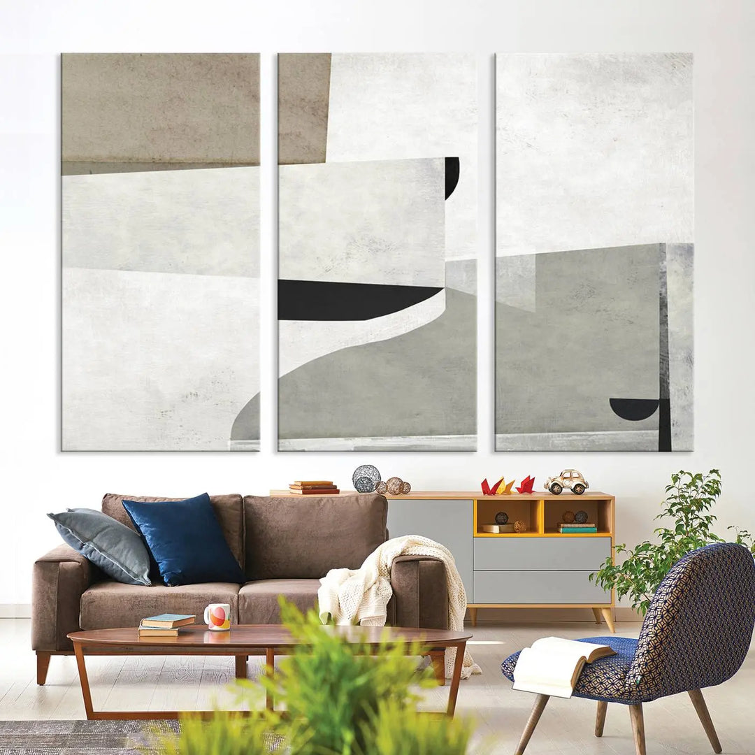 The Brown Gray Figures Abstract Wall Art Canvas Print is displayed as a triptych on a dark wall. The piece is gallery wrapped, offering a seamless finish and enhanced durability due to its UV-protective coating.