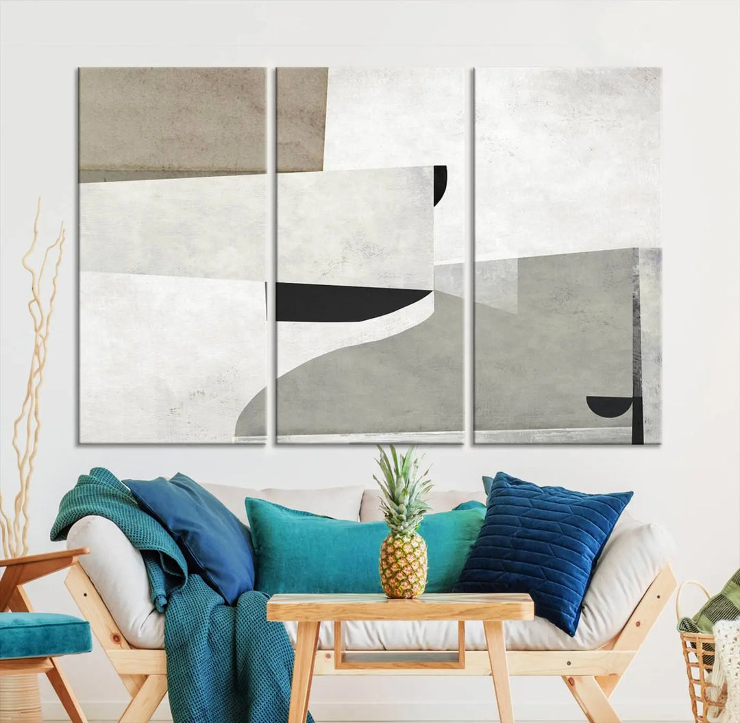 The Brown Gray Figures Abstract Wall Art Canvas Print is displayed as a triptych on a dark wall. The piece is gallery wrapped, offering a seamless finish and enhanced durability due to its UV-protective coating.