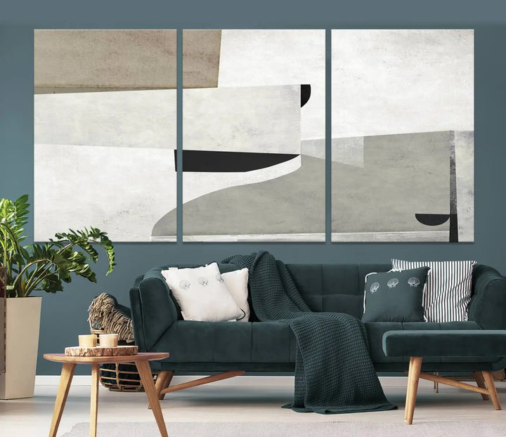 The Brown Gray Figures Abstract Wall Art Canvas Print is displayed as a triptych on a dark wall. The piece is gallery wrapped, offering a seamless finish and enhanced durability due to its UV-protective coating.