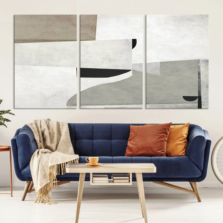 The Brown Gray Figures Abstract Wall Art Canvas Print is displayed as a triptych on a dark wall. The piece is gallery wrapped, offering a seamless finish and enhanced durability due to its UV-protective coating.