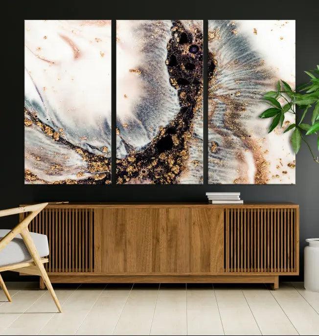 The Brown Marble Fluid Effect Wall Art Abstract Canvas Wall Art Print, with its mesmerizing black, white, and gold swirls, brings an exquisite touch to the space. This museum-quality canvas is elegantly displayed in a modern living room setting.