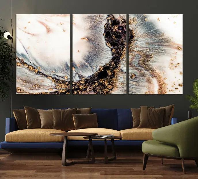 The Brown Marble Fluid Effect Wall Art Abstract Canvas Wall Art Print, with its mesmerizing black, white, and gold swirls, brings an exquisite touch to the space. This museum-quality canvas is elegantly displayed in a modern living room setting.