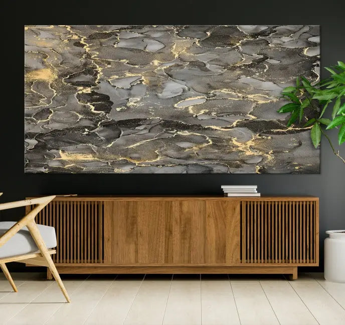 The Brown Yellow Marble Fluid Effect Abstract Canvas Wall Art Print, expertly wrapped on museum-quality canvas, enhances the dark wall with intricate gold and gray swirls.