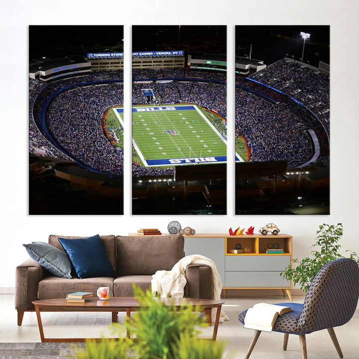 Above the couch hangs a museum-quality triptych featuring the Buffalo Bills NFL Football Team: a stunning canvas print of Highmark Stadium packed with enthusiastic spectators at night. The high-resolution printing technique captures every detail to perfection, making it ready to hang and instantly elevate any space.