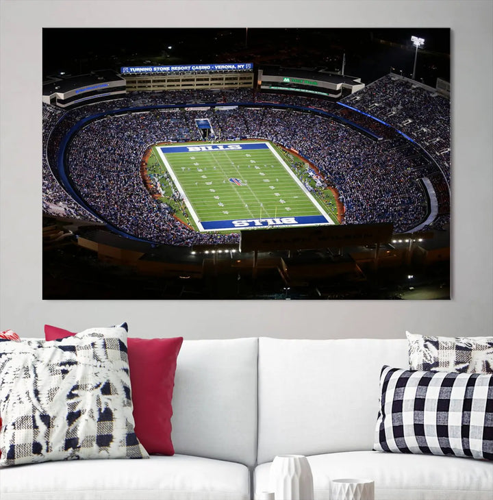 Above the couch hangs a museum-quality triptych featuring the Buffalo Bills NFL Football Team: a stunning canvas print of Highmark Stadium packed with enthusiastic spectators at night. The high-resolution printing technique captures every detail to perfection, making it ready to hang and instantly elevate any space.