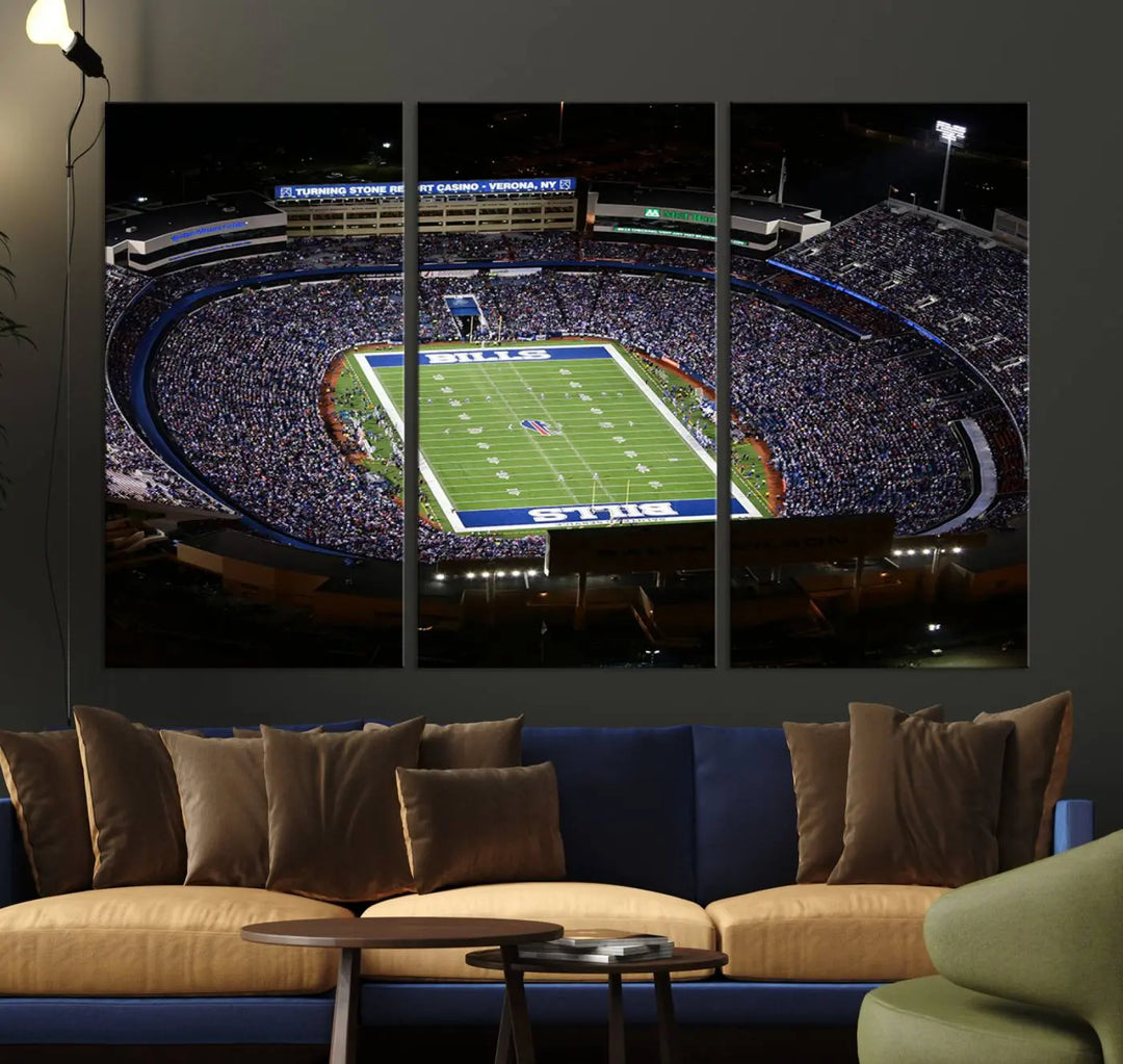 Above the couch hangs a museum-quality triptych featuring the Buffalo Bills NFL Football Team: a stunning canvas print of Highmark Stadium packed with enthusiastic spectators at night. The high-resolution printing technique captures every detail to perfection, making it ready to hang and instantly elevate any space.