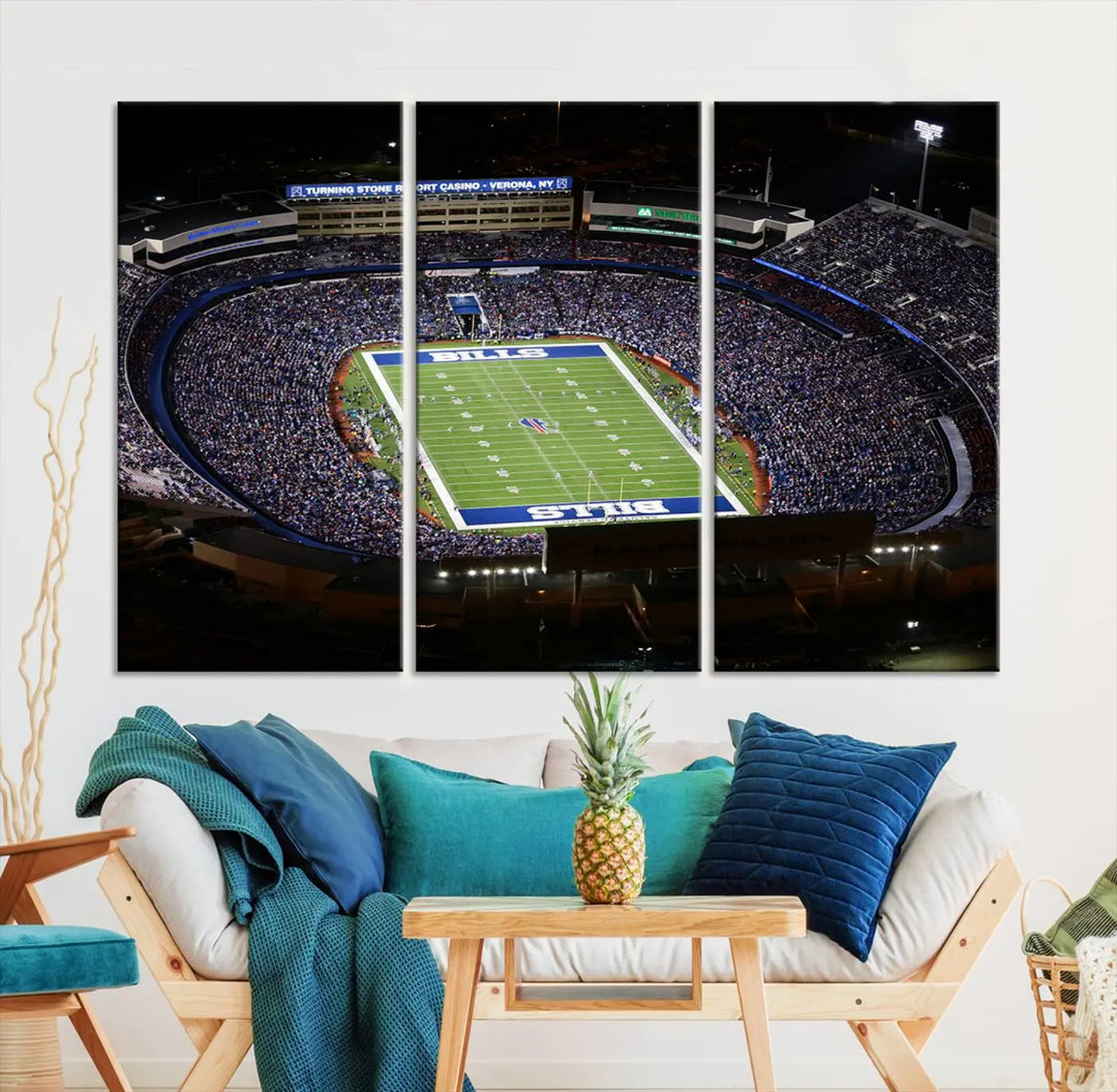 Above the couch hangs a museum-quality triptych featuring the Buffalo Bills NFL Football Team: a stunning canvas print of Highmark Stadium packed with enthusiastic spectators at night. The high-resolution printing technique captures every detail to perfection, making it ready to hang and instantly elevate any space.